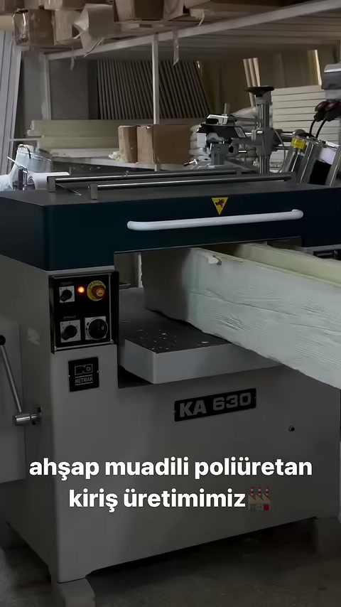 Açık renkli kiriş, profil makinesinin giriş tablasında bekliyor.