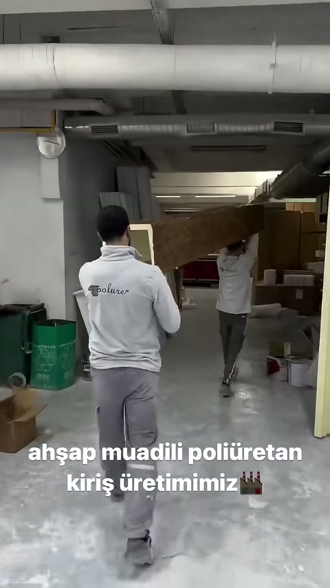 Kahverengi dekoratif kiriş üretim alanından raflara doğru götürülüyor.