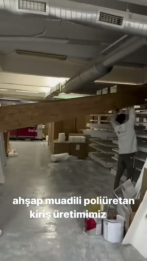 Uzun ahşap desenli mertek atölye koridorunda ilerletiliyor.
