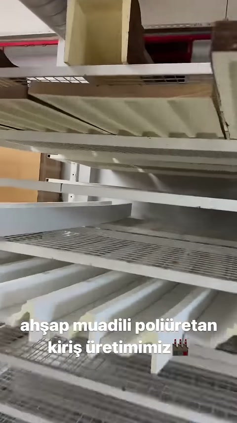 Açık renkli dekoratif profiller depolama raflarında yatay sergileniyor.