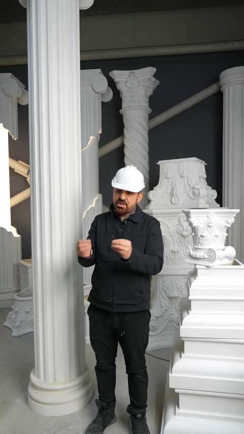 Sunucu, yüksek yivli sütun ile süslü kaide arasında duruyor.