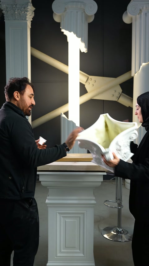 İki kişi dekoratif sütun başlığının iç yüzeyini inceliyor