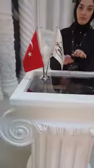 Sunucu, volüt süslemeli sehpa modülünün arkasında açıklama yapıyor