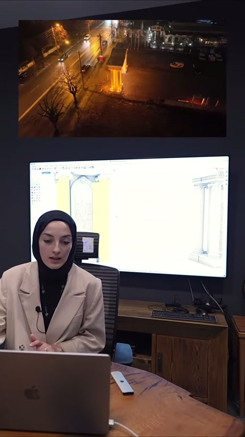 Sunucu, bilgisayarın yanında dekoratif sütun taslaklarını anlatmayı sürdürüyor.