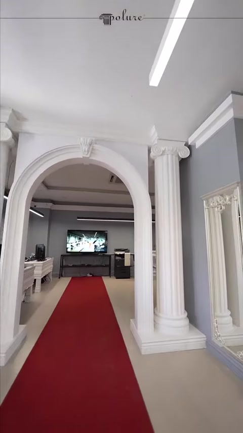 İki dekoratif sütunla çevrelenen kemerli showroom geçişi