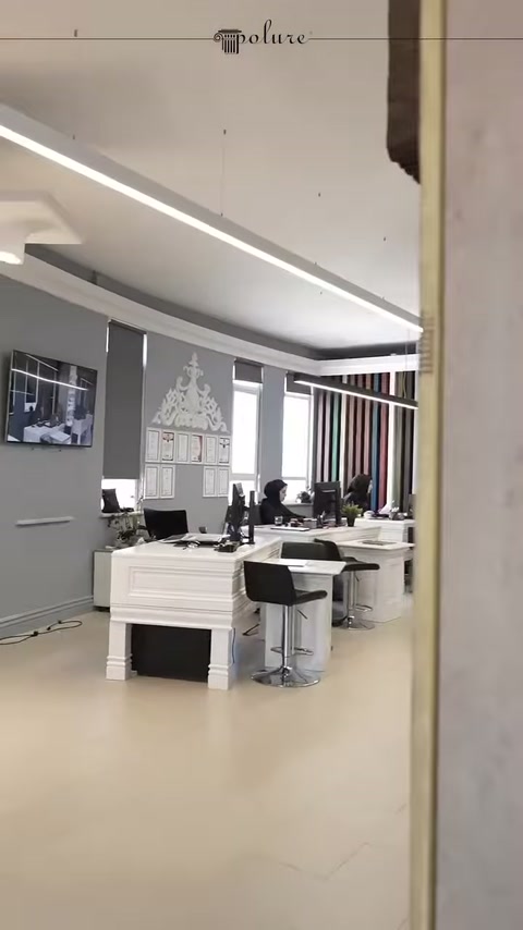 Beyaz çalışma masalarının bulunduğu dekorasyon showroomu genel görünümü sunuluyor