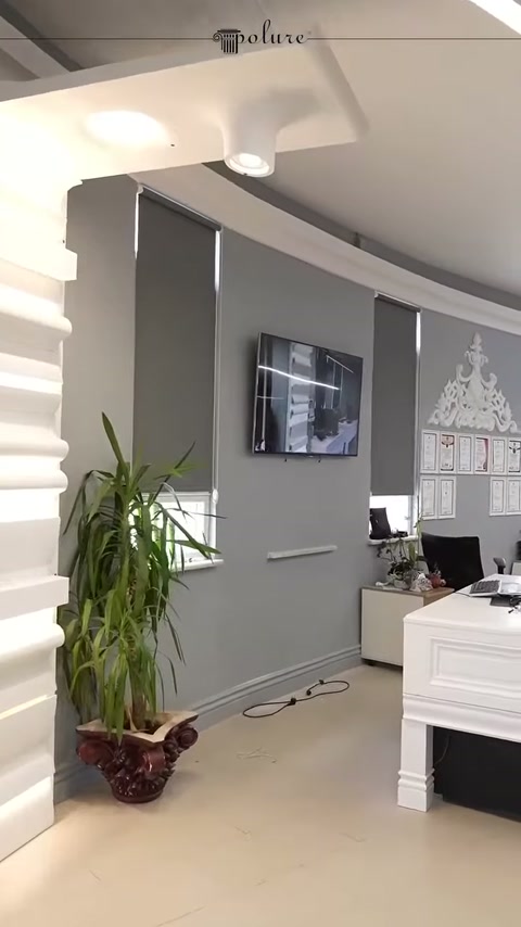 Tavandaki dekoratif konsollar ve gri duvarlı çalışma alanı görülüyor
