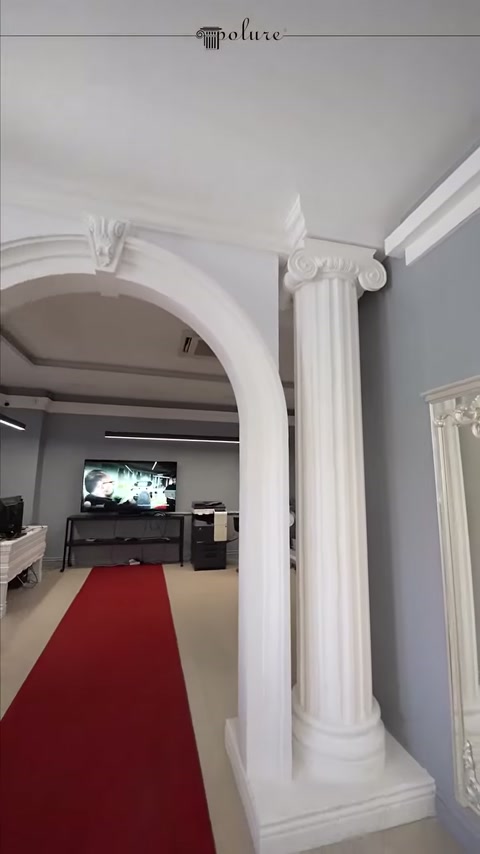 Beyaz kemer takımı kırmızı halılı showroom koridorunu çerçeveliyor