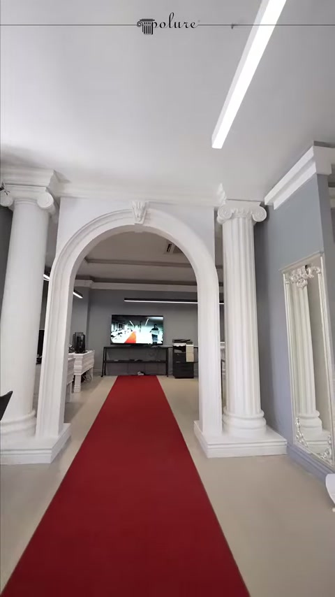 Kırmızı halı boyunca uzanan sütunlu kemer düzeni genel görünümü sunuluyor