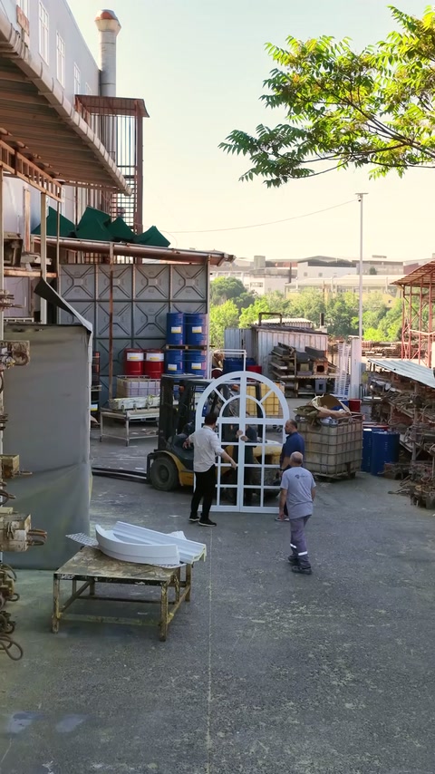 Çalışanlar büyük kemerli pencere kombinasyonunu atölye bahçesinde ayağa kaldırıyor