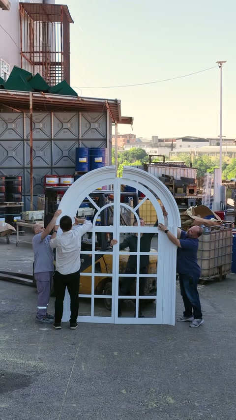Çalışanlar pencerenin kavisli dış çerçevesini iki yandan sabit tutuyor